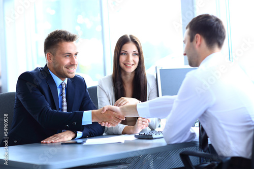 Photo: businessman shaking hands to seal a deal with his partner businessman shaking hands to seal a deal with his partner