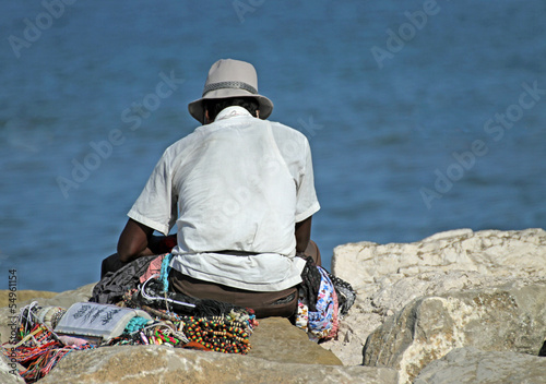 Photo: peddler of necklaces and accessories rests on the Pier by the se peddler of necklaces and accessories rests on the Pier by the se