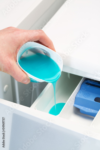 Photo: Pouring detergent in washing machine Pouring detergent in washing machine