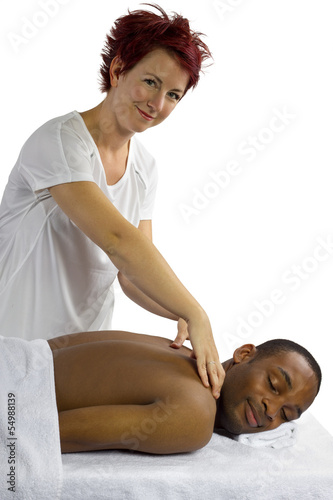 Photo: young female masseuse treating young male client with massage young female masseuse treating young male client with massage