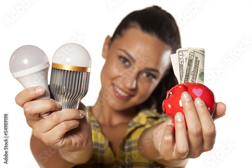 Photo: Smiling girl shows that you can save money with LED bulbs Smiling girl shows that you can save money with LED bulbs