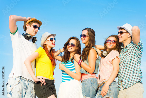 Photo: group of young people wearing sunglasses and hat group of young people wearing sunglasses and hat