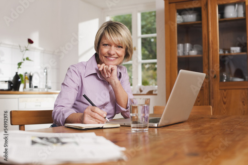 Photo: Deutschland, Kratzeburg, erwachsene Frau mit Notizbuch und Laptop Deutschland, Kratzeburg, erwachsene Frau mit Notizbuch und Laptop