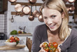 Foto: Italien, Toskana, Magliano, Junge Frau zwinkert und hält Tomaten in der Küche, Lächeln Italien, Toskana, Magliano, Junge Frau zwinkert und hält Tomaten in der Küche, Lächeln