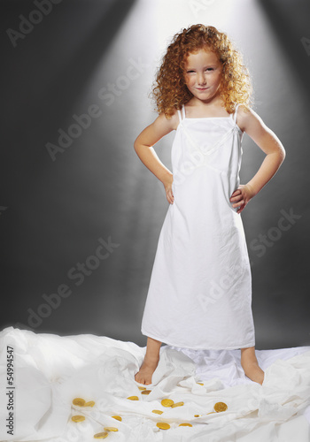 Photo: Mädchen mit Goldmünzen auf dem Bett Mädchen mit Goldmünzen auf dem Bett
