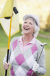 Foto: Italien, Kastelruth, erwachsene Frau mit Golfschläger und Golf-Flagge auf Golfplatz Italien, Kastelruth, erwachsene Frau mit Golfschläger und Golf-Flagge auf Golfplatz