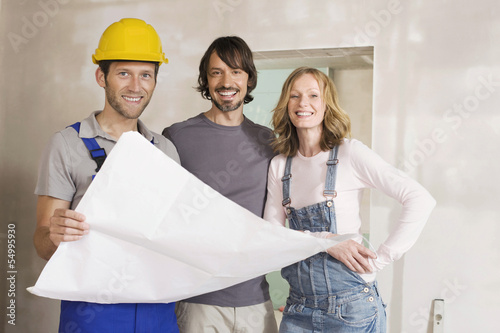 Photo: Junges Paar und Bauarbeiter, Blick in den Bauplan Junges Paar und Bauarbeiter, Blick in den Bauplan