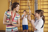 Photo: Deutschland, Emmering, Frau und Mädchen mit Gymnastikringen mit Jungen im Hintergrund Deutschland, Emmering, Frau und Mädchen mit Gymnastikringen mit Jungen im Hintergrund