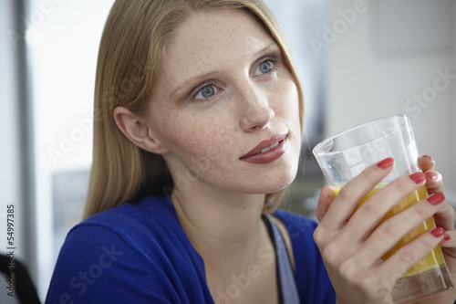 Photo: Deutschland, Köln, junge Frau mit Saft in Wohnung Deutschland, Köln, junge Frau mit Saft in Wohnung