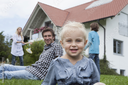 Photo: Deutschland, München, Mädchen mit Familie im Hintergrund Deutschland, München, Mädchen mit Familie im Hintergrund