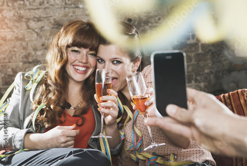 Photo: Deutschland, Berlin, Junge Frauen mit Champagner-Glas und ein Mann, machen Fotos Deutschland, Berlin, Junge Frauen mit Champagner-Glas und ein Mann, machen Fotos