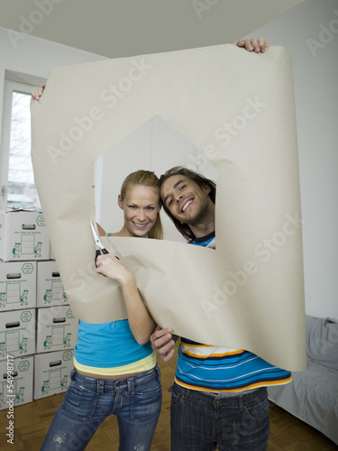 Photo: Paar schaut durch Loch im Papier Paar schaut durch Loch im Papier