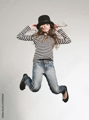 Photo: Mädchen mit Hut springt Mädchen mit Hut springt