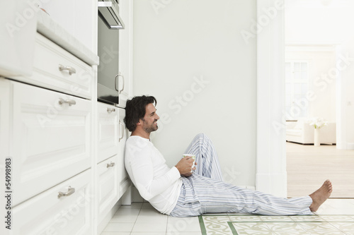 Photo: Deutschland, Berlin, erwachsener Mann mit Kaffeetasse in der Küche, Lächeln Deutschland, Berlin, erwachsener Mann mit Kaffeetasse in der Küche, Lächeln