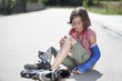 Foto: Deutschland, Bayern, Verletztes Mädchen sitzedn auf der Straße nach Inline-Skating Unfall Deutschland, Bayern, Verletztes Mädchen sitzedn auf der Straße nach Inline-Skating Unfall