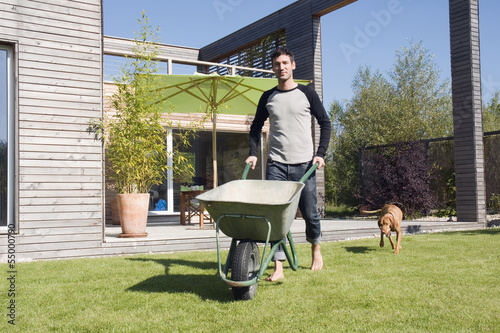 Photo: Deutschland, Bayern, München, Mann im Garten, schiebt Schubkarre Deutschland, Bayern, München, Mann im Garten, schiebt Schubkarre