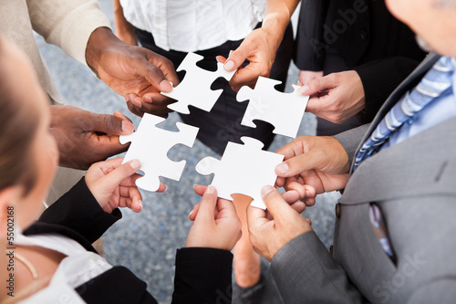 Photo: Businesspeople Holding Jigsaw Puzzle Businesspeople Holding Jigsaw Puzzle