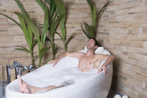 Photo: Mann liegt in der Badewanne, die Augen geschlossen Mann liegt in der Badewanne, die Augen geschlossen