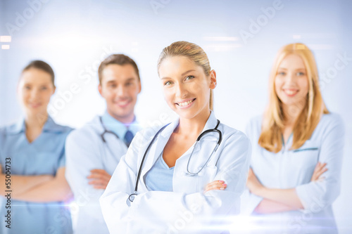 Photo: female doctor in front of medical group female doctor in front of medical group