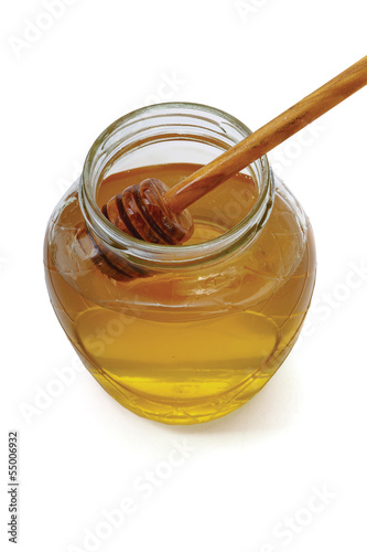 Photo: Honey with wood stick , isolated on white background Honey with wood stick , isolated on white background