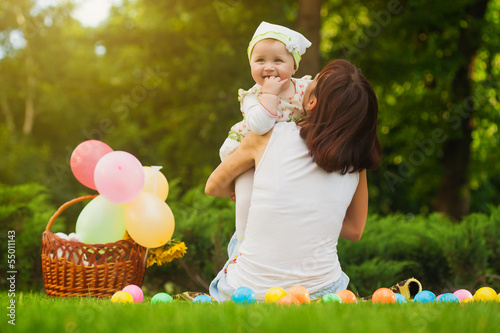 Photo: cute baby and mom are playing on the green grass cute baby and mom are playing on the green grass