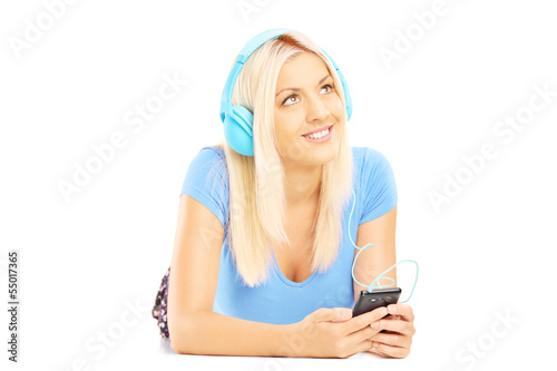 Photo: Young relaxing female lying and listening music Young relaxing female lying and listening music