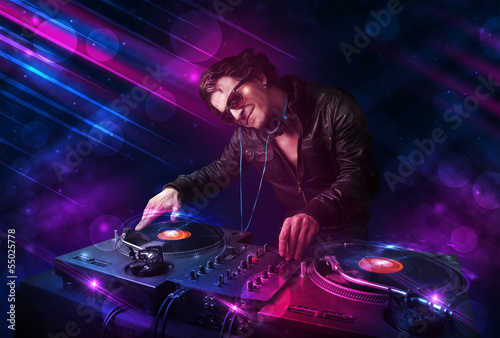 Photo: Young DJ playing on turntables with color light effects Young DJ playing on turntables with color light effects
