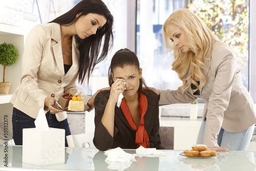 Photo: Young office workers comforting crying colleague Young office workers comforting crying colleague