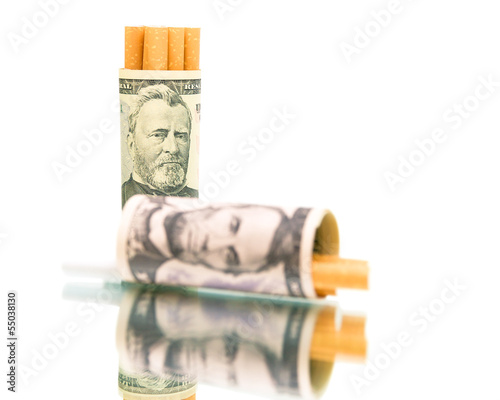 Photo: habit. money and cigarettes on a white background close-up. habit. money and cigarettes on a white background close-up.