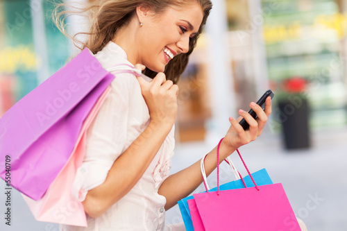Photo: Woman with mobile phone and shopping bags Woman with mobile phone and shopping bags