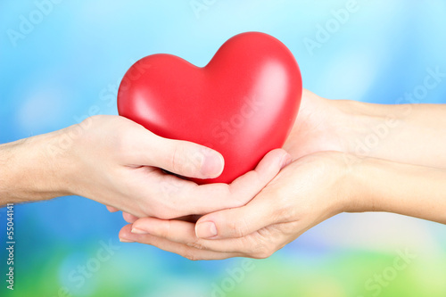 Photo: Hearts in hands on nature background Hearts in hands on nature background