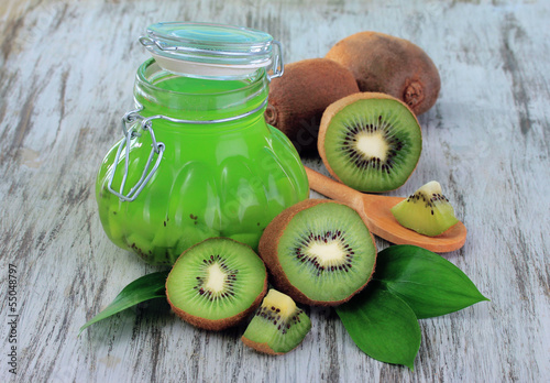 Photo: Jar of jam kiwi on wooden table close-up Jar of jam kiwi on wooden table close-up