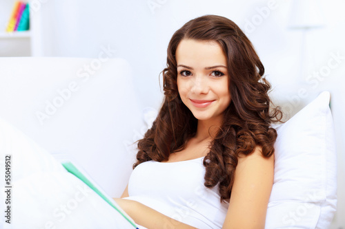 Photo: Young woman at home with a book Young woman at home with a book