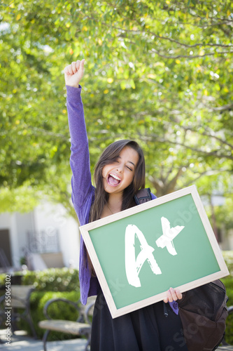 Photo: Mixed Race Female Student Holding Chalkboard With A+ Written Mixed Race Female Student Holding Chalkboard With A+ Written