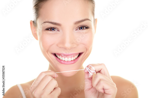 Photo: Dental flush - woman flossing teeth smiling Dental flush - woman flossing teeth smiling