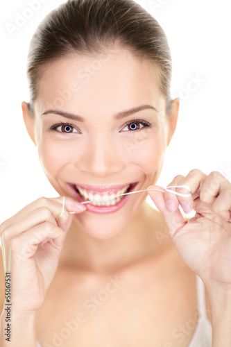 Photo: Woman flossing teeth smiling using dental flush Woman flossing teeth smiling using dental flush