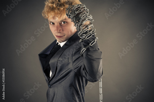 Photo: young businessman raises his arm up with a chain young businessman raises his arm up with a chain