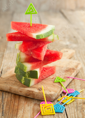 Photo: Slices of watermelon on wooden chopping board Slices of watermelon on wooden chopping board