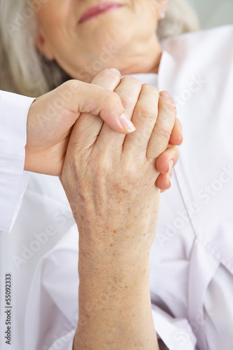 Photo: Arzt hält Hand einer Seniorin im Krankenhaus Arzt hält Hand einer Seniorin im Krankenhaus