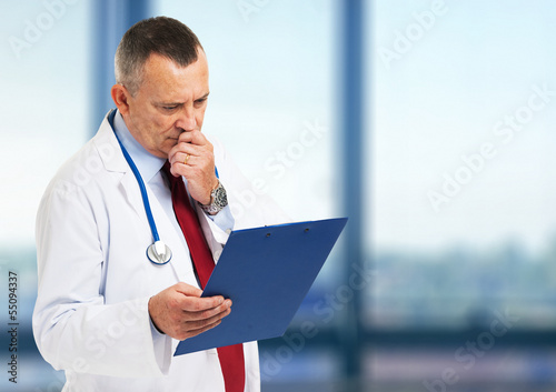 Photo: Doctor reading a case history Doctor reading a case history