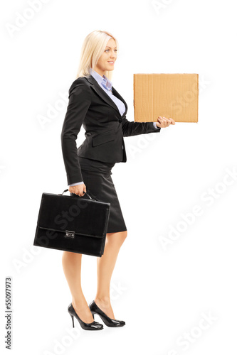 Photo: Full length portrait of a young woman in suit holding a card Full length portrait of a young woman in suit holding a card