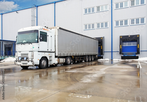 Photo: Unloading big container trucks at warehouse building Unloading big container trucks at warehouse building
