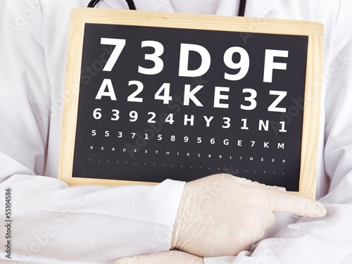 Photo: Ophthalmologist holding blackboard with eyesight test Ophthalmologist holding blackboard with eyesight test