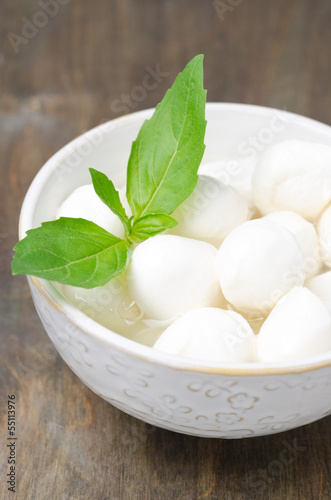 Photo: fresh mozzarella and basil in a bowl, close-up fresh mozzarella and basil in a bowl, close-up