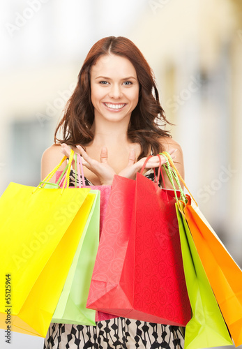 Photo: woman holding color shopping bags in mall woman holding color shopping bags in mall