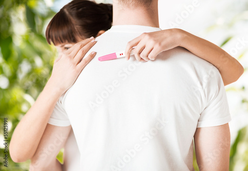 Photo: woman with pregnancy test hugging man woman with pregnancy test hugging man