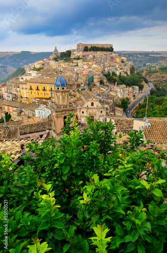Photo: View of beautiful village Ragusa with green tree foreground View of beautiful village Ragusa with green tree foreground