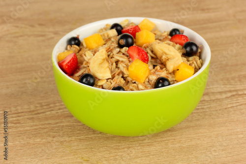 Photo: Oatmeal with fruits on table close-up Oatmeal with fruits on table close-up