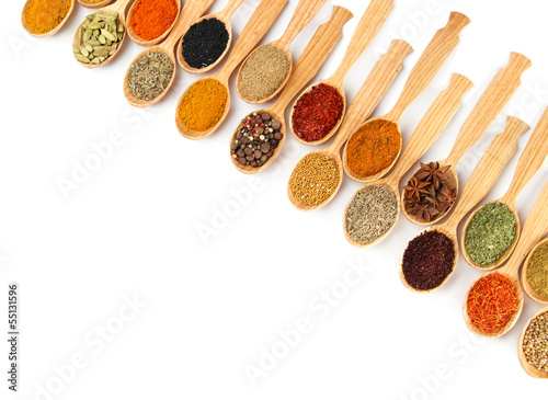 Photo: Assortment of spices in wooden spoons, isolated on white Assortment of spices in wooden spoons, isolated on white