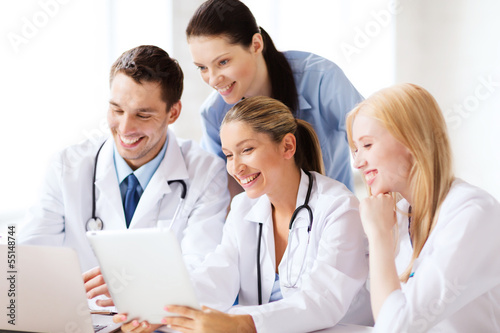 Photo: group of doctors looking at tablet pc group of doctors looking at tablet pc